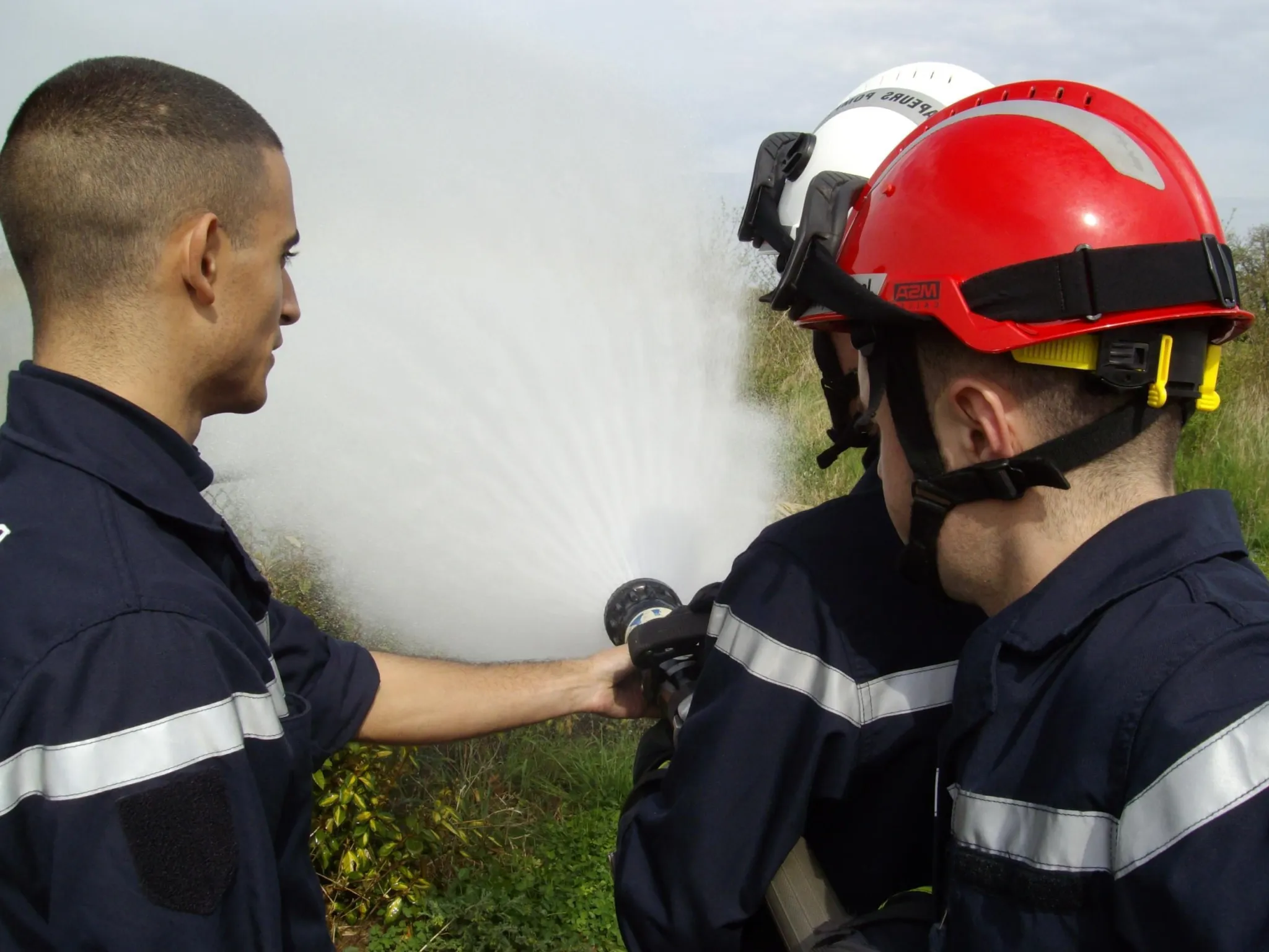 formation-formateur-incendie Trois formateurs utilisant un jet d'eau pour l'incendie